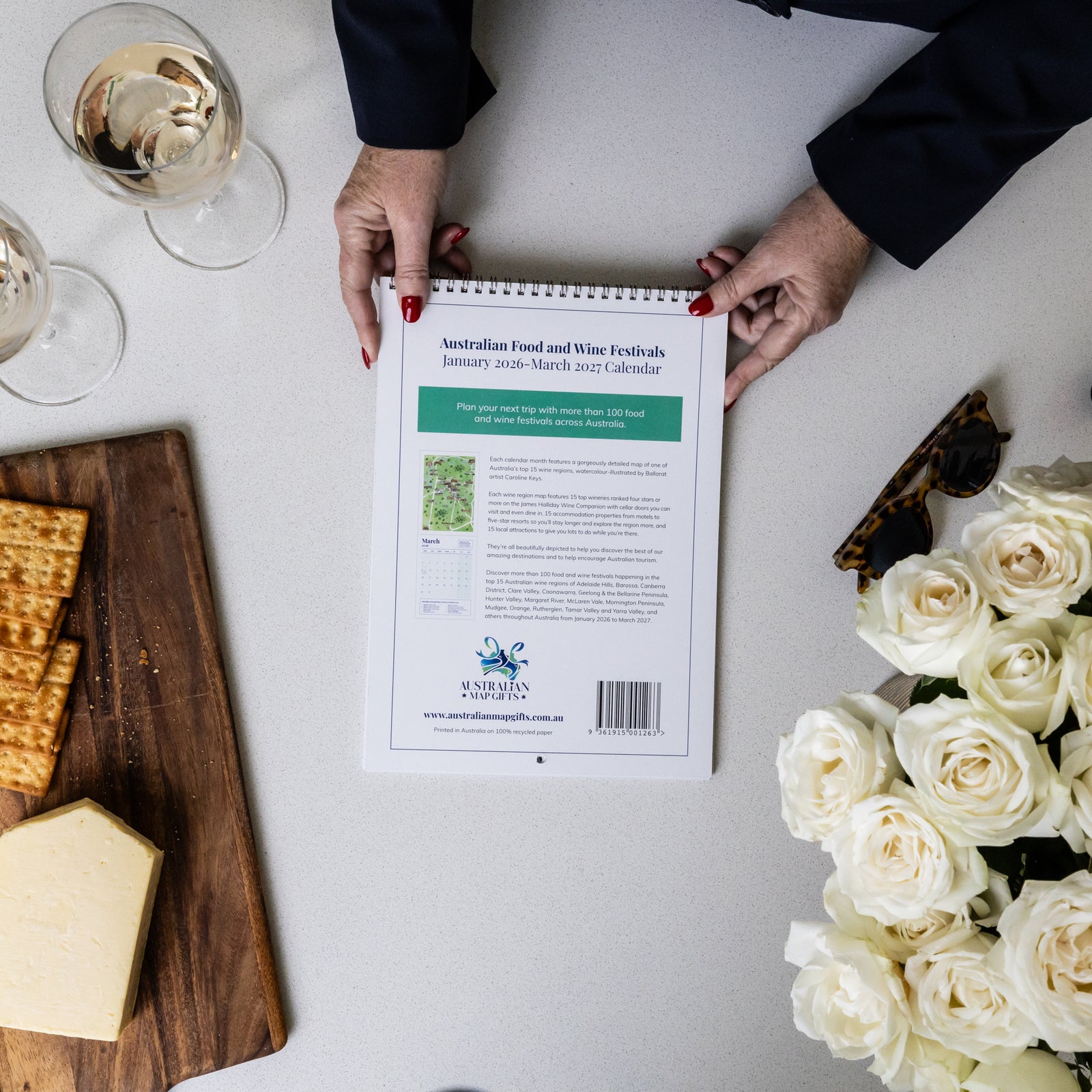 HANDS HOLDING BACK COVER OF AUSTRALIAN FOOD AND WINE FESTIVALS CALENDAR